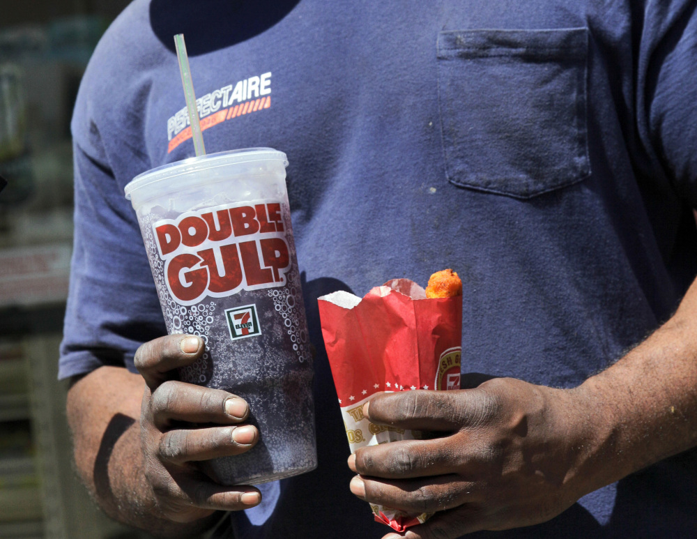 A man leaves a 7-Eleven store with a Double Gulp drink. The New York Court of Appeals ruled Thursday that the city's health department overstepped its bounds when it restricted the size of sodas. The Associated Press