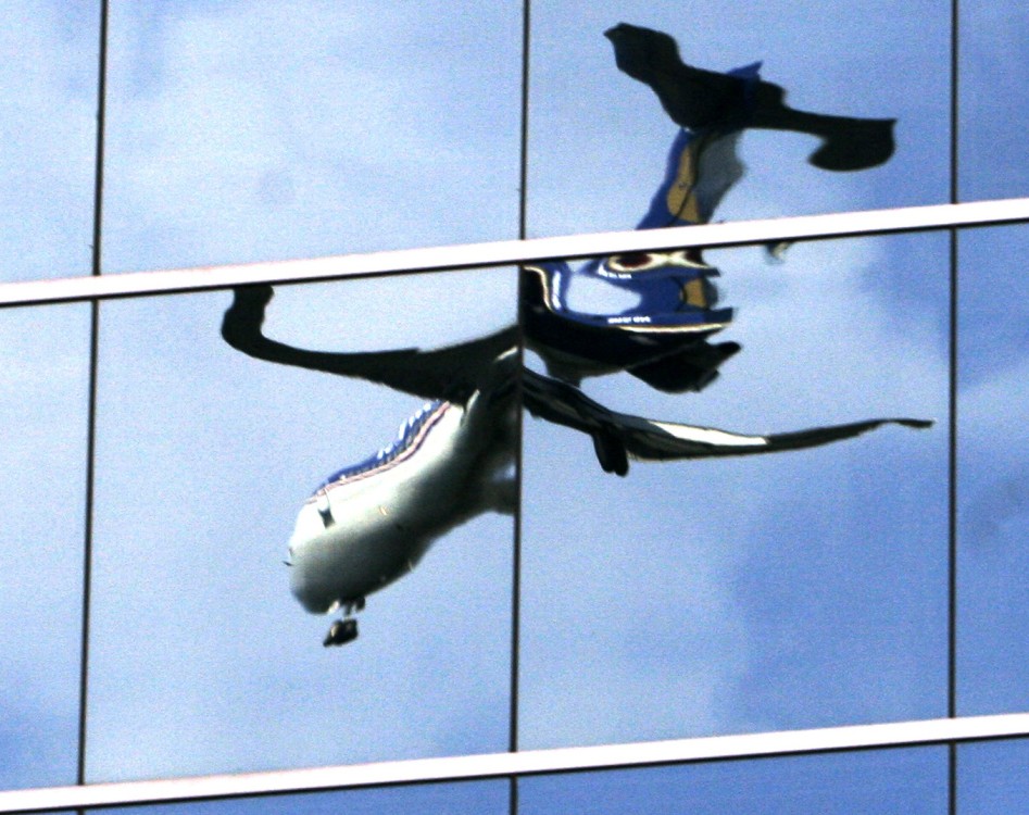 A  passenger jet landing at Washington’s Reagan National Airport in Roslyn, Va., is reflected in the mirrored windows of an office building.