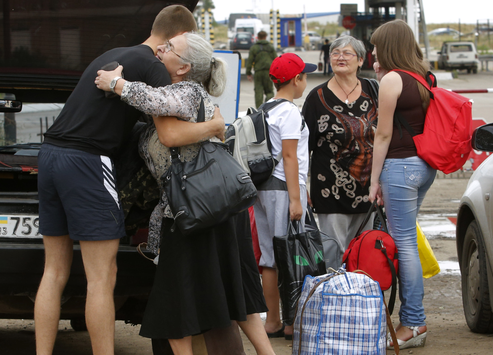 A man says goodbye to his relatives as they prepare to cross the border into Russia at the Ukrainian-Russian border checkpoint in the Luhansk region of Ukraine on Thursday