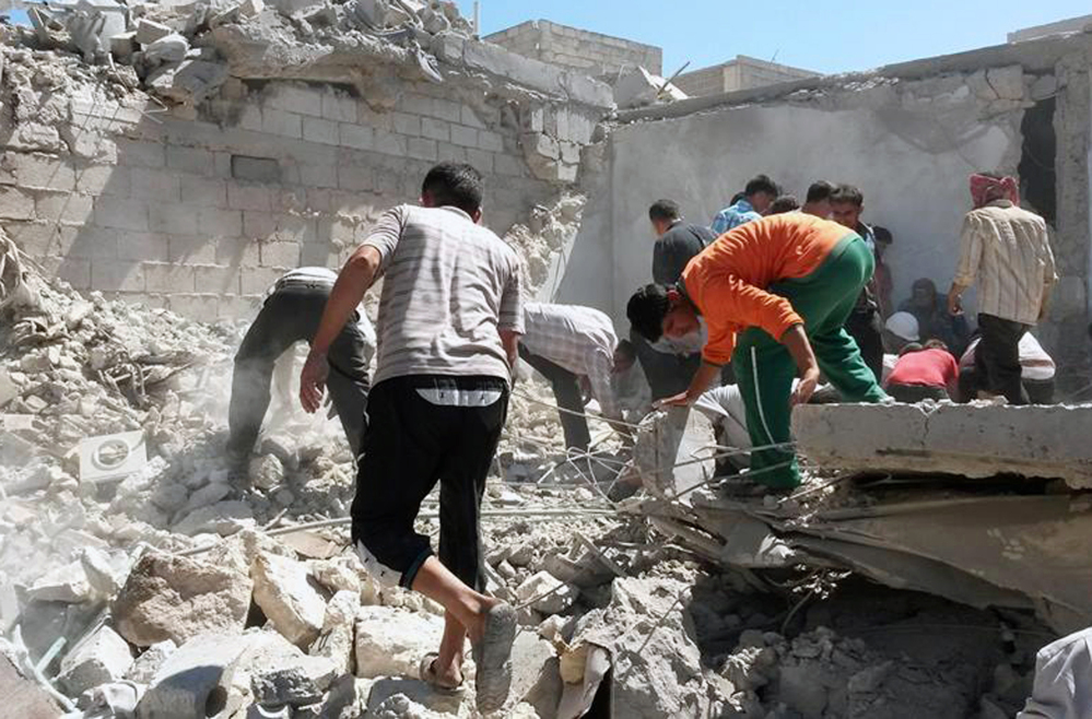 This photo provided by the anti-government activist group Syrian Observatory for Human Rights shows Syrians inspecting the rubble of destroyed houses following a Syrian government airstrike in Aleppo on Wednesday, June. 25, 2014. Syrian government warplanes struck a series of targets in the northern city that is a stronghold of an al-Qaida splinter group, killing and wounding several people, opposition activists said.