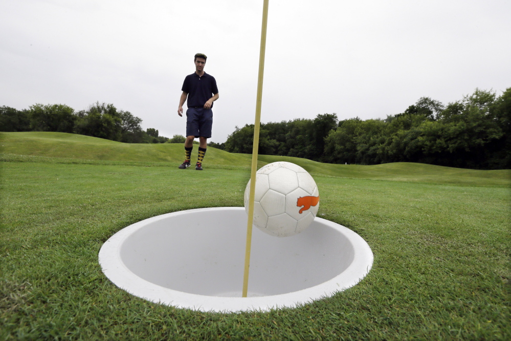 Brian Eggenberger putts his ball during a round of FootGolf at Fox Hills Golf Course in Salem Township, Michigan. Players “tee off” by kicking a soccer ball from a tee box. They follow the basic rules of golf from there, advancing the ball until it drops into the oversized hole.