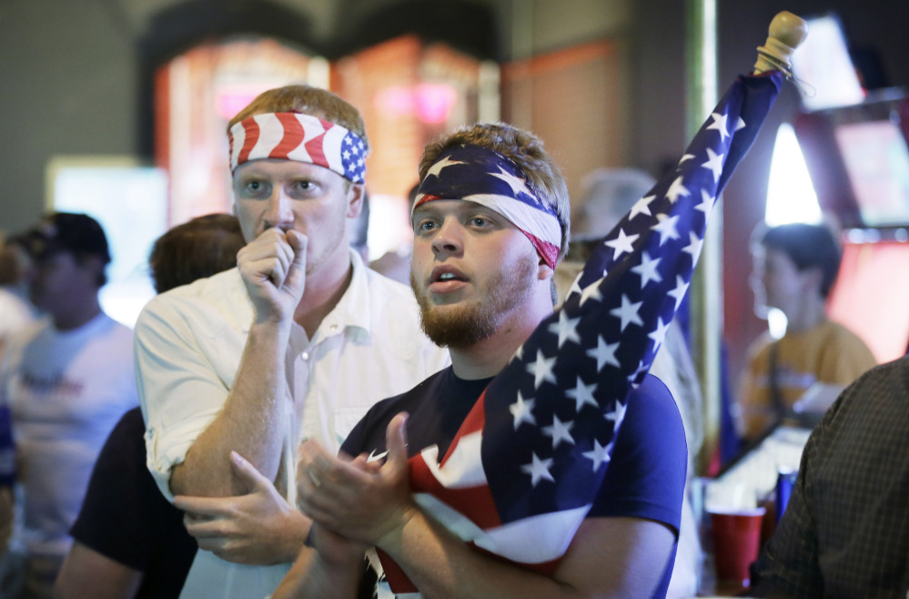 Aaron Todd, right, and Zach Crabtree, both of Knoxville, Iowa, react as they watch the World Cup Soccer match between the United States and Germany at a bar, Thursday, June 26, 2014, in West Des Moines, Iowa. Thousands of eager Americans set work aside on Thursday – with or without their bosses’ OK – to watch the key World Cup match. Todd and Crabtree said they took the day off to watch the match.
