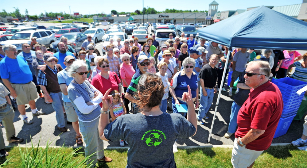 Lissa Bittermann, foreground, of Ecomaine, talks to Waterville residents Friday about the city’s recycling program.