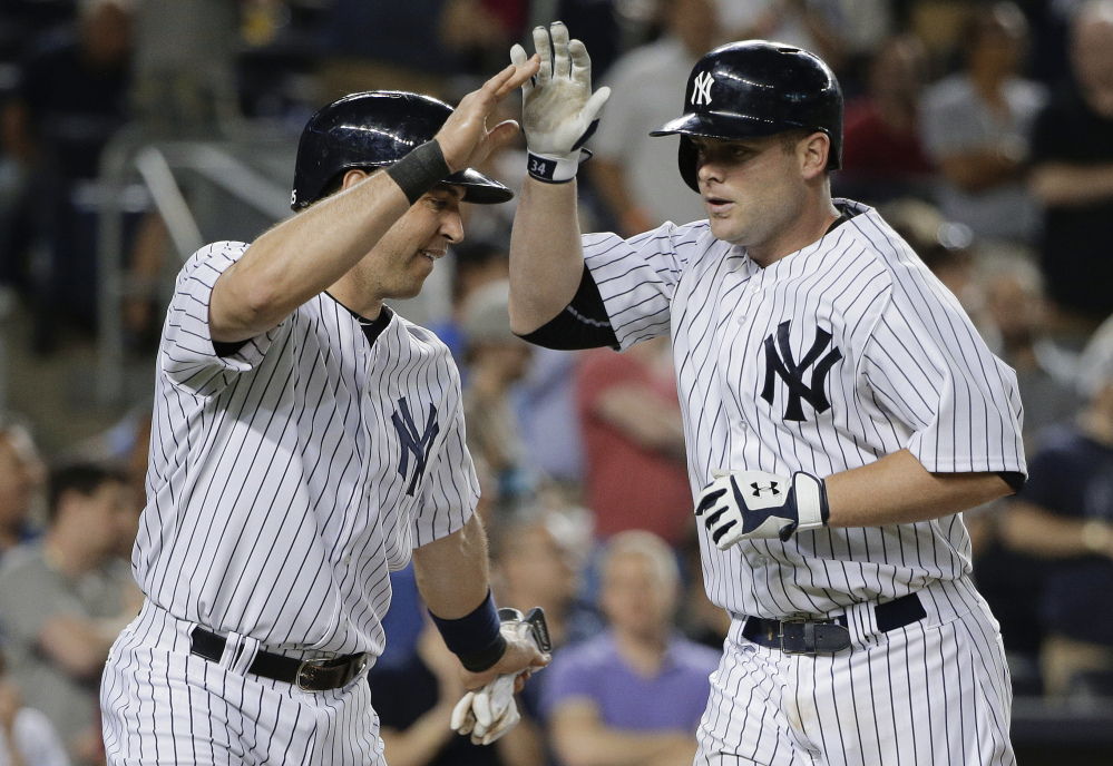 New York Yankees’ Brian McCann, right, is greeted at home plate by Mark Teixeira after hitting a two-run home run in the 8th inning against the Boston Red Sox. The Yankees won 6-0.