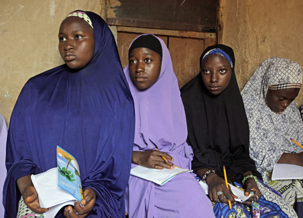 Maimuna Abdullahi, left, listens as she and others attend school in Kaduna, Nigeria. She is one of thousands of divorced girls in Nigeria who were married as children and then got thrown out by their husbands or simply fled.