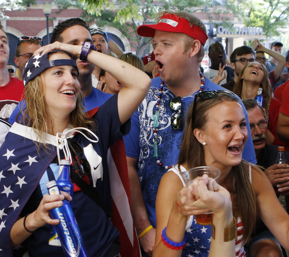 Passion and patriotism are on the sleeves of Ally Goodman, left, and Callie Pote in Denver as they watch the U.S. team fall to Germany 1-0 in a World Cup match Thursday. The American team still advance to the Round of 16 and will play Belguim on Tuesday.