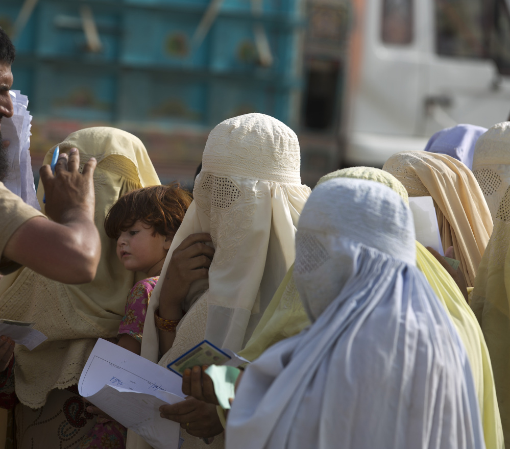A Pakistani soldier checks documents of displaced tribal women in Bannu.