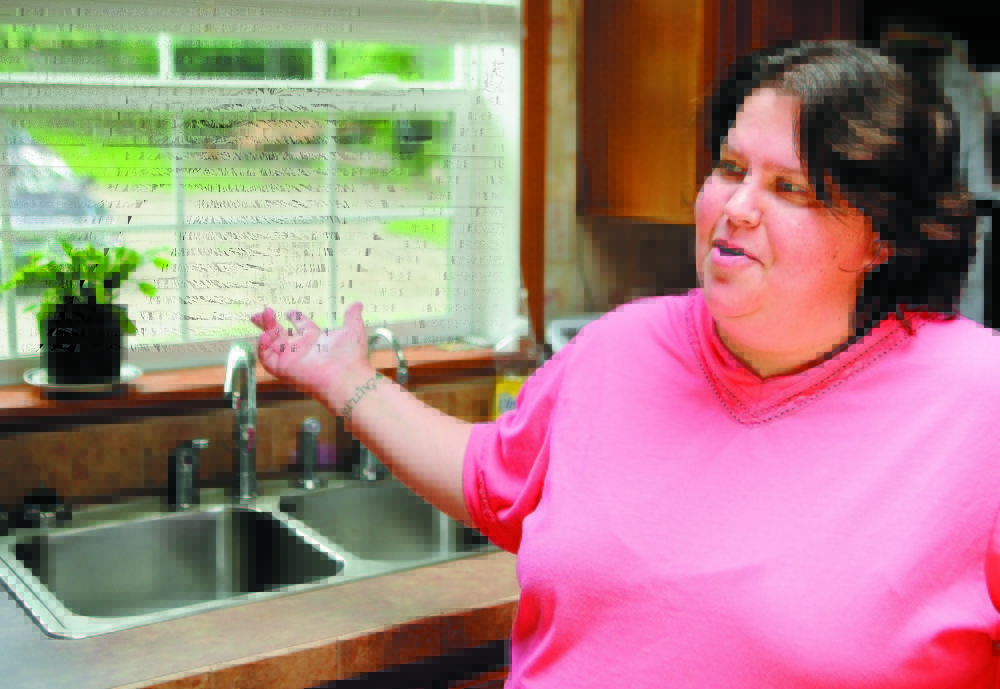 Wendy Brennan talks in 2011 about the reverse-osmosis arsenic filtration system in her Mount Vernon home, where she lives with her two daughters and two grandchildren. Brennan had the filtration system installed after she participated in a study that found levels of arsenic in her well water were more than five times the federal standard.