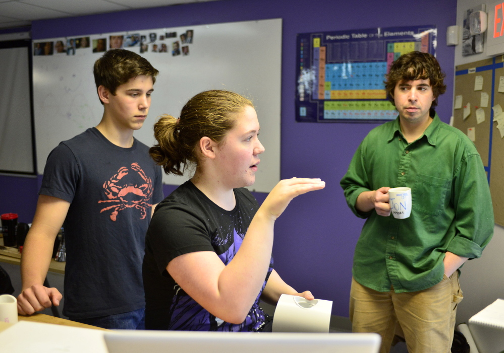 Baxter Academy student Erin Whitney talks about her team’s engineering project this month as student Caedan Holdan, left, and engineering teacher Jonathan Amory listen. The students worked on their independent projects each Friday during the school year and then displayed their innovations.