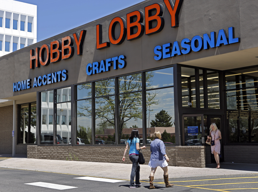 In this May 22, 2013, customers enter and exit a Hobby Lobby store in Denver.