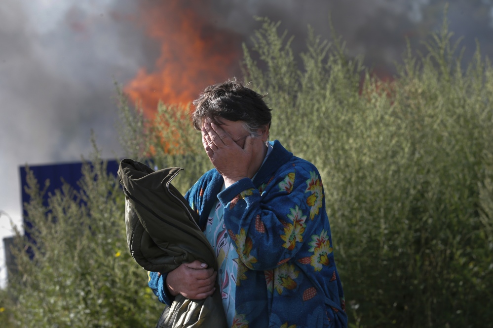 A woman cries near her burning house after shelling in the city of Slovyansk, eastern Ukraine, on Monday.