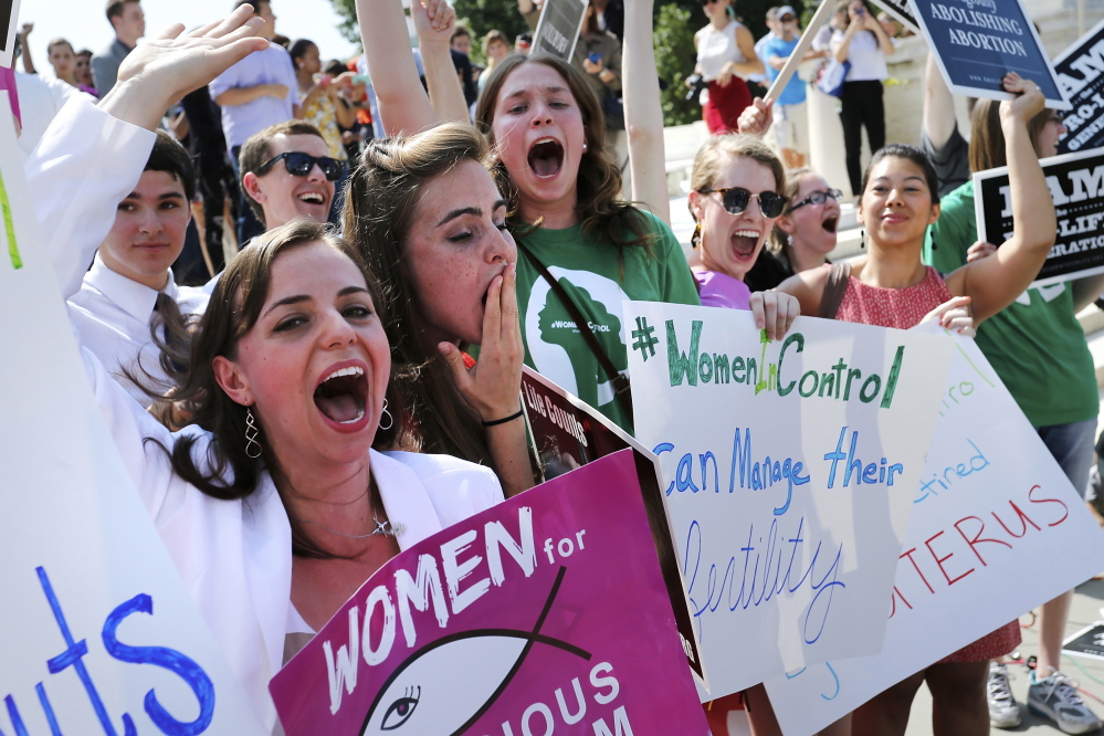 Anti-abortion demonstrators cheer as the ruling for Hobby Lobby was announced outside the U.S. Supreme Court in Washington June 30, 2014. The U.S. Supreme Court on Monday ruled that business owners can object on religious grounds to a provision of U.S. President Barack Obama's healthcare law that requires closely held private companies to provide health insurance that covers birth control. REUTERS/Jonathan Ernst (UNITED STATES - Tags: CIVIL UNREST RELIGION POLITICS HEALTH) - RTR3WH66