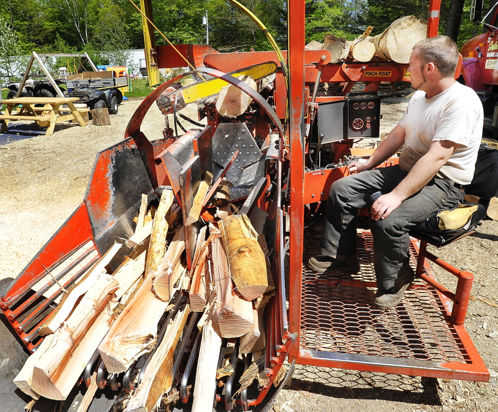 WINDHAM, ME - MAY 21:  Mike Killinger, owner of Maine Logging, works on the cutting machine as he works with his father to cut and process firewood for sale. (Photo by Gordon Chibroski/Staff Photographer)