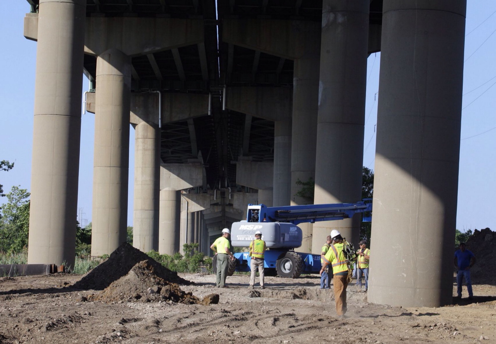 The Associated Press DelDot crew members surround a tilted column supporting a span of the I-495 bridge over the Christina River on Monday. The 4,800-foot bridge normally carries about 90,000 vehicles a day on I-495, which diverts traffic around the city of Wilmington.