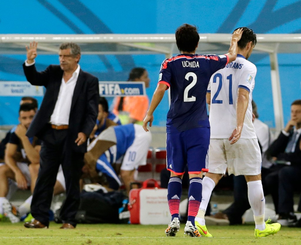 Japan's Atsuto Uchida (2) pats Greece's Kostas Katsouranis (21) on the head after Katsouranis was sent off by referee Joel Aguilar from El Salvador during the group C World Cup soccer match between Japan and Greece.