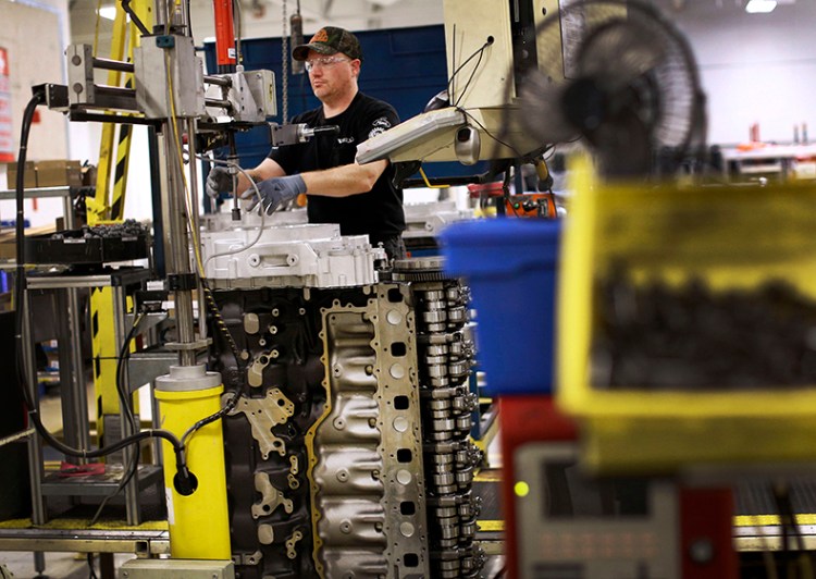 In this March 26, 2014 photo, Jerry Drury installs parts on a truck engine assembly line at Volvo Trucks' powertrain manufacturing facility in Hagerstown, Md.