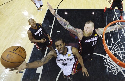 San Antonio Spurs forward Kawhi Leonard shoots between Miami Heat guard Ray Allen and forward Chris Andersen during the second half in Game 5 of the NBA basketball finals Sunday in San Antonio. The Associated Press