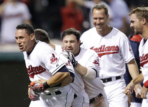 Teammates mob Indians shortstop Asdrubal Cabrera, front, after he hit a game-winning three-run home run off Red Sox relief pitcher Edward Mujica in the 12th inning Thursday in Cleveland. The Associated Press