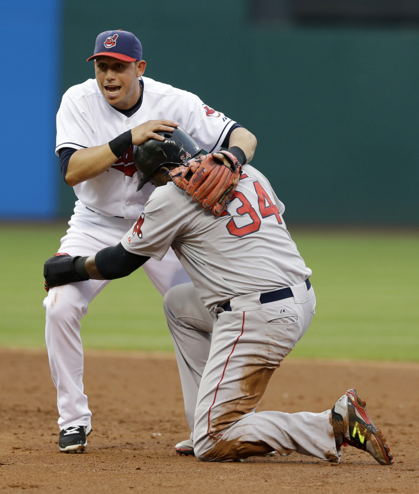 Cleveland Indians' Asdrubal Cabrera, top, holds onto Boston Red Sox's David Ortiz after Ortiz was out at second base on a double play in the third inning of a baseball game, Monday, June 2, 2014, in Cleveland. A.J. Pierzynski was out at first base. (AP Photo/Tony Dejak)