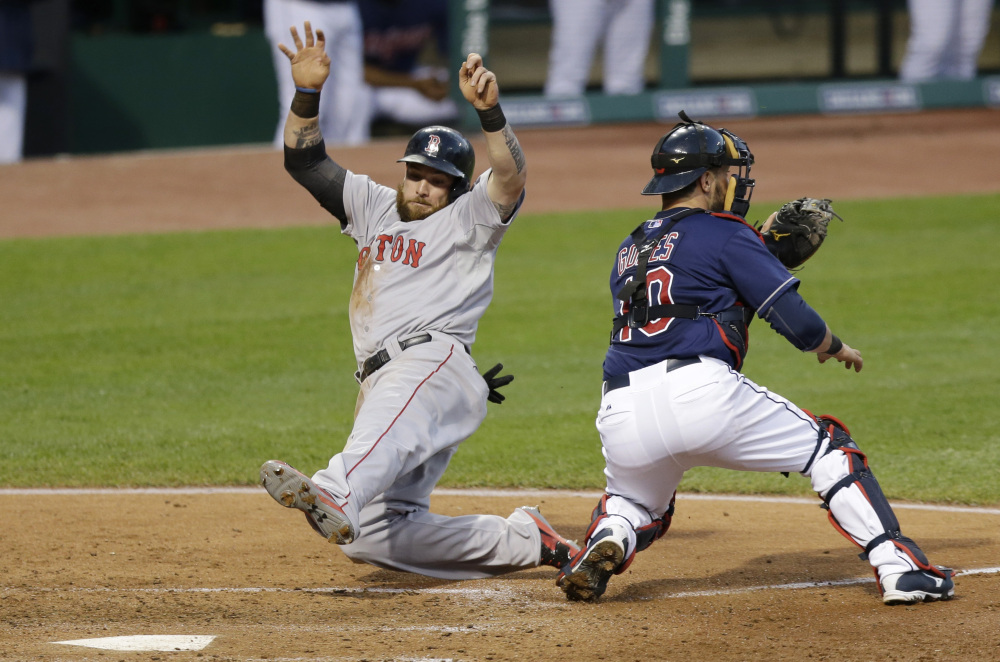 Boston Red Sox's Jonny Gomes, left, scores as Cleveland Indians catcher Yan Gomes waits for the ball in the sixth inning of a baseball game, Tuesday, June 3, 2014, in Cleveland. Gomes scored on a single by Jonathan Herrera. (AP Photo/Tony Dejak)