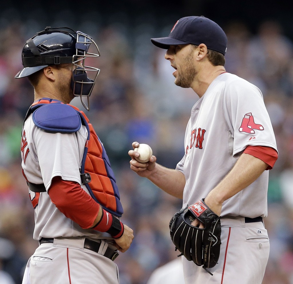 Boston Red Sox starting pitcher John Lackey talks with catcher A.J. Pierzynski after Lackey gave up a run to the Seattle Mariners in the fourth inning Monday in Seattle.