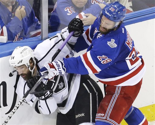 New York Rangers center Dominic Moore crashes the boards against Los Angeles Kings right wing Justin Williams in the third period of Game 4 of the NHL Stanley Cup Final on Wednesday in New York. The Rangers won the game 2-1. The Associated Press
