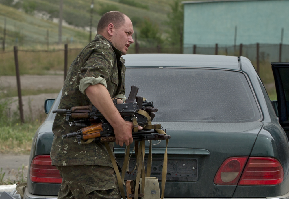 The Associated Press A pro-Russian rebel loads a car with weapons seized from a Ukrainian military unit in eastern Ukraine on Wednesday.