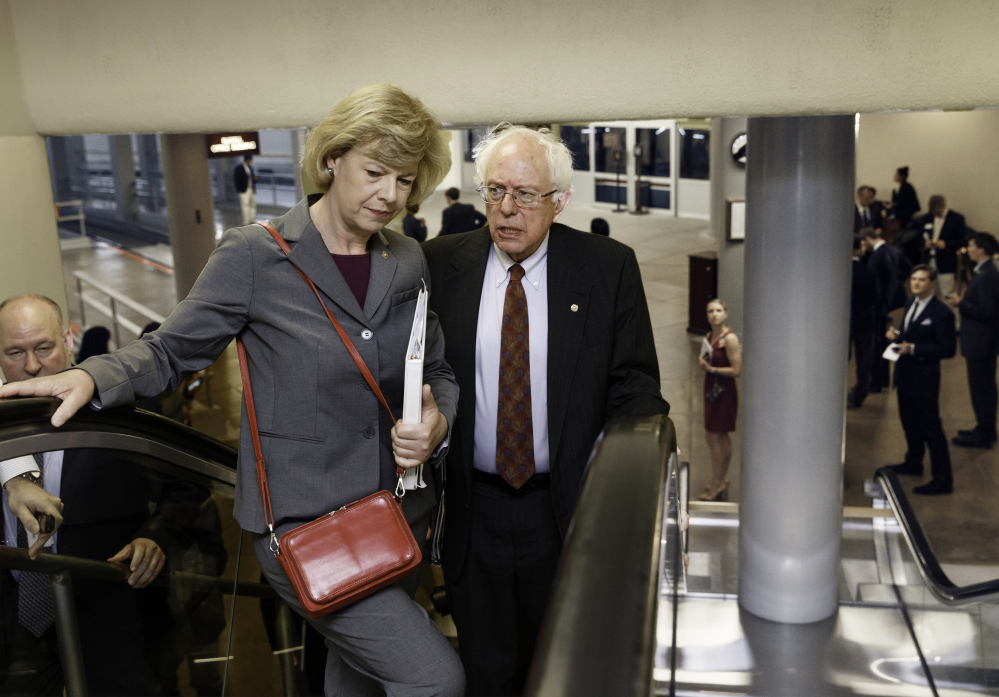 Senate Veterans Affairs Committee Chairman Sen. Bernie Sanders, I-Vt., and Sen. Tammy Baldwin, D-Wis., head to the Senate chamber Wednesday. Sanders proposed legislation this week that would allow veterans who can't get timely appointments with VA doctors to go to community health centers, military hospitals or private doctors. The Associated Press