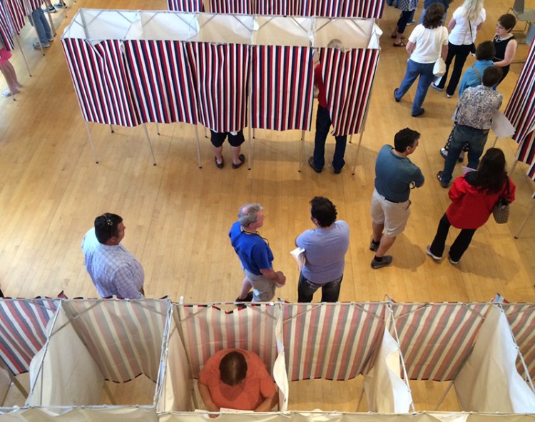 In this file photo voters line up to have their ballots scanned in Kennebunk town hall. Gregory Rec/Staff Photographer
