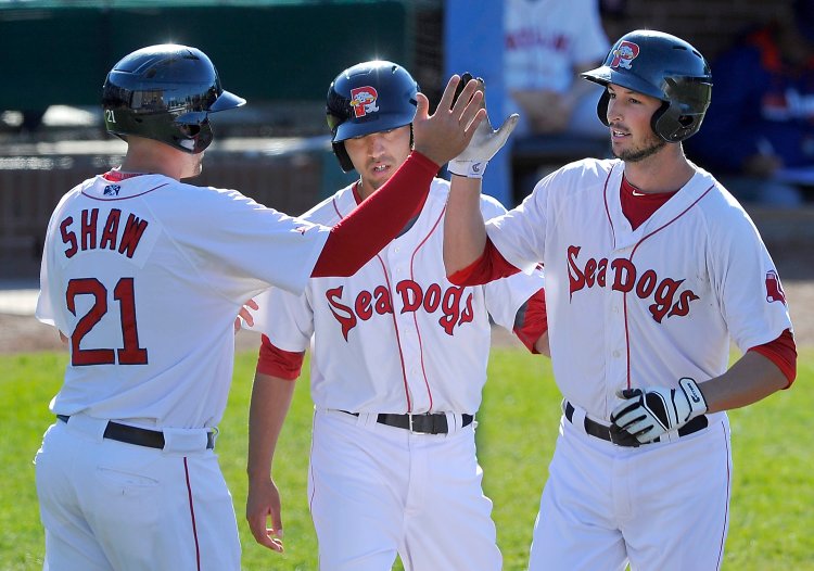 Portland Sea Dog Stefan Welch is greeted by base runners Travis Shaw and Derrik Gibson after hitting a three-run homer at Hadlock Field in May. 2014 Press Herald file