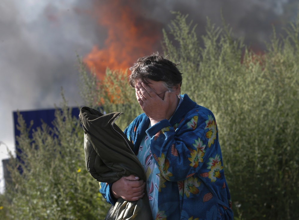 A woman cries near her burning house after shelling occurred in the city of Slovyansk, eastern Ukraine, on Monday. Continued violation of a cease-fire has led Ukraine’s recently elected president to declare an offensive against pro-Russian separatists.