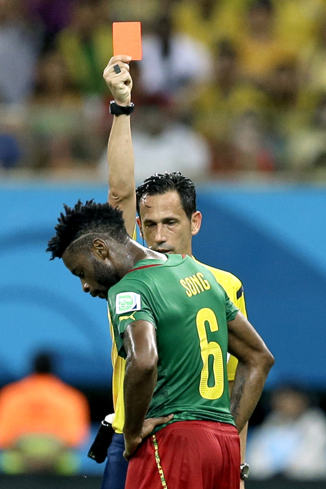 In this Wednesday, June 18, 2014 file photo, referee Pedro Proenca from Portugal gives a red card to Cameroon’s Alex Song during the group A World Cup soccer match between Cameroon and Croatia at the Arena da Amazonia in Manaus, Brazil. Cameroon’s football federation said late Monday, June 30, 2014, it will investigate allegations of match-fixing by its team at the World Cup and the possible existence of “seven bad apples” in the squad.