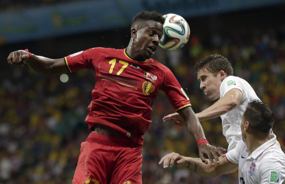 Belgium’s Divock Origi heads the ball over United States’ Matt Besler and Geoff Cameron, right, during the World Cup round of 16 soccer match between Belgium and the USA at the Arena Fonte Nova in Salvador, Brazil, on Tuesday.