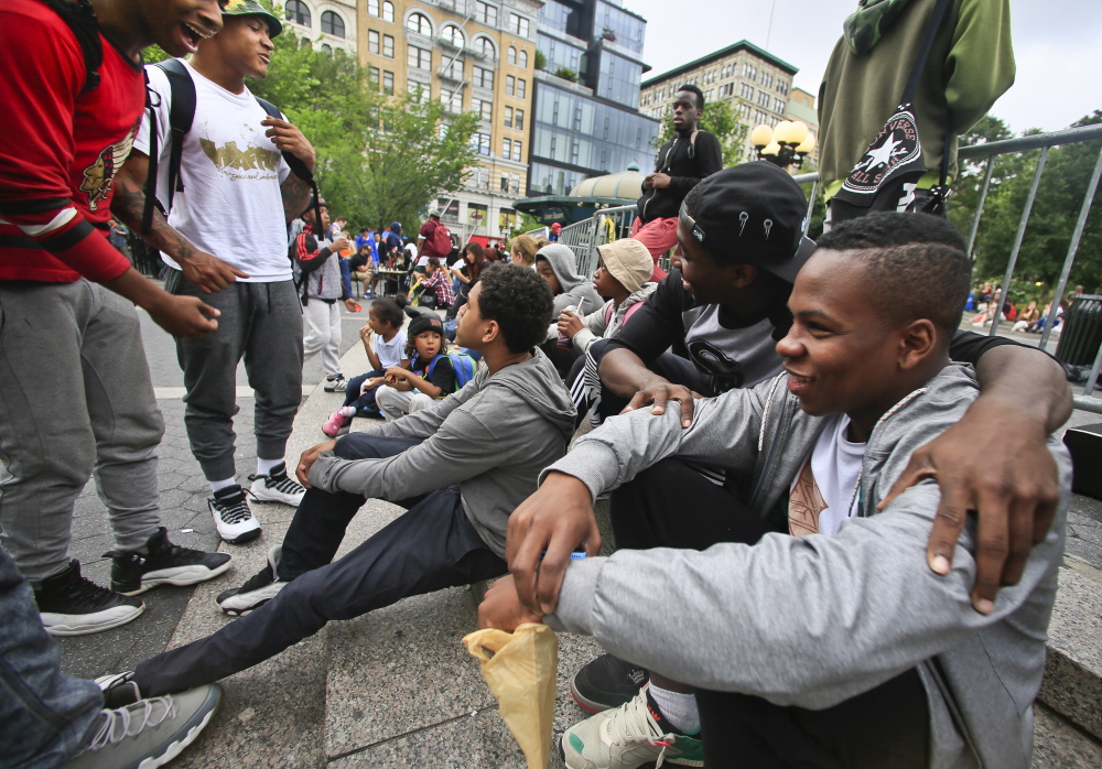 In this June 12, 2014 photo, Andrew Sanders, right, leader of the dance troupe W.A.F.F.L.E., which stands for We Are Family For Life Entertainment, meets with members of his squad in Union Square, New York. “We’re not just knuckleheads. ... We’re actually about something,” said Saunders. (AP Photo/Bebeto Matthews)