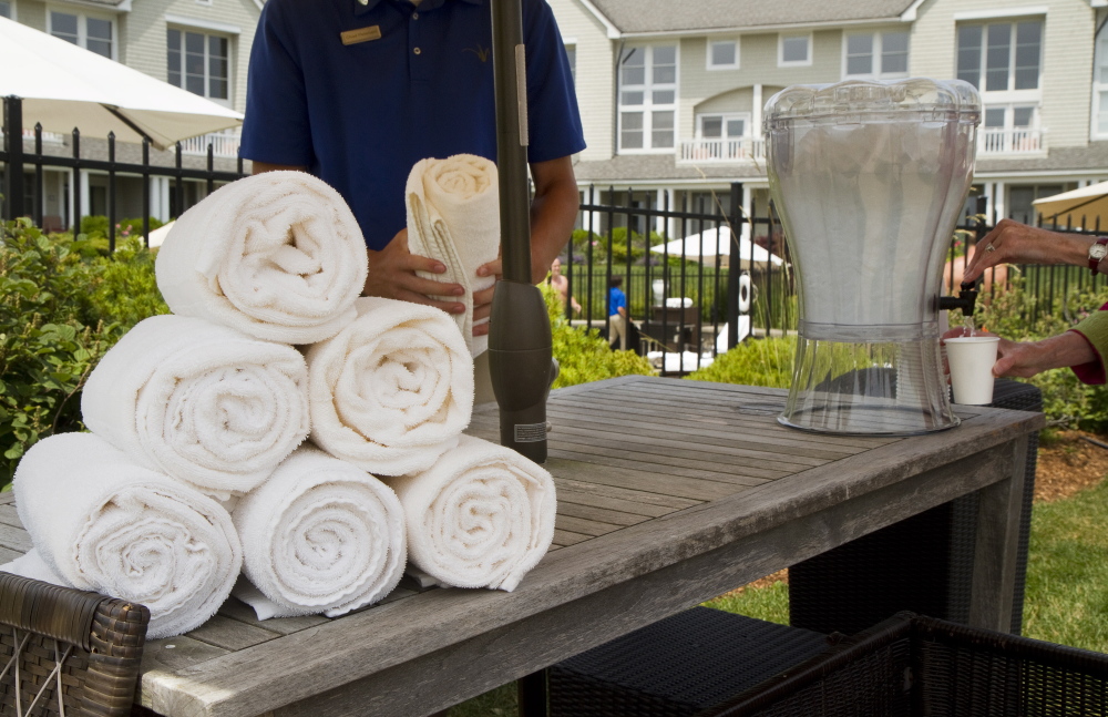 An Inn by the Sea staff member folds towels for guests by the pool. Business at Maine tourist hotspots is on its best pace since 2005. Carl D. Walsh/Staff Photographer 