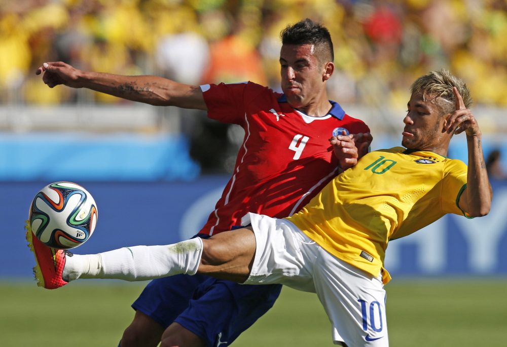 Brazil’s Neymar, right, fights for the ball with Chile’s Mauricio Isla during their World Cup round of 16 soccer match at Mineirao Stadium in Belo Horizonte, Brazil, on Saturday.