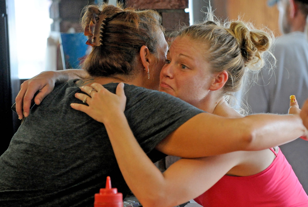 Bolley’s Famous Franks manager Zena McFadden, left, gets a hug Thursday from loyal customer Lindsey Doyle at the eatery in Waterville.