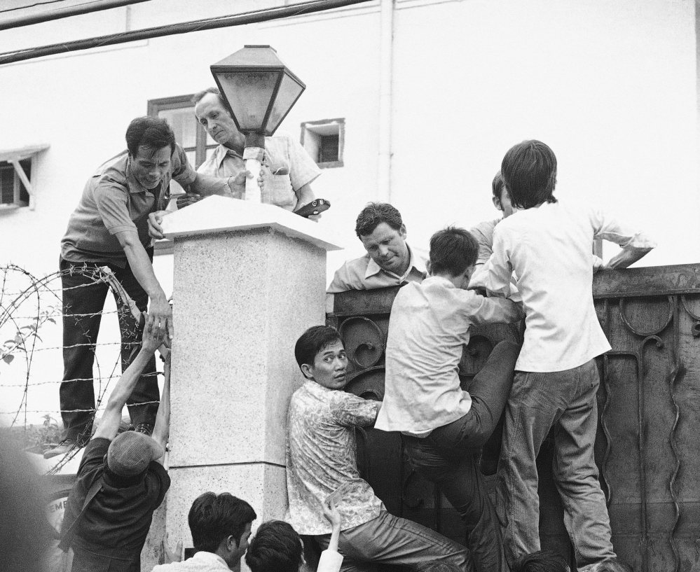 Vietnamese try to scale the U.S. Embassy wall in desperate attempts to get aboard the evacuation flights in Saigon on May 1, 1975.