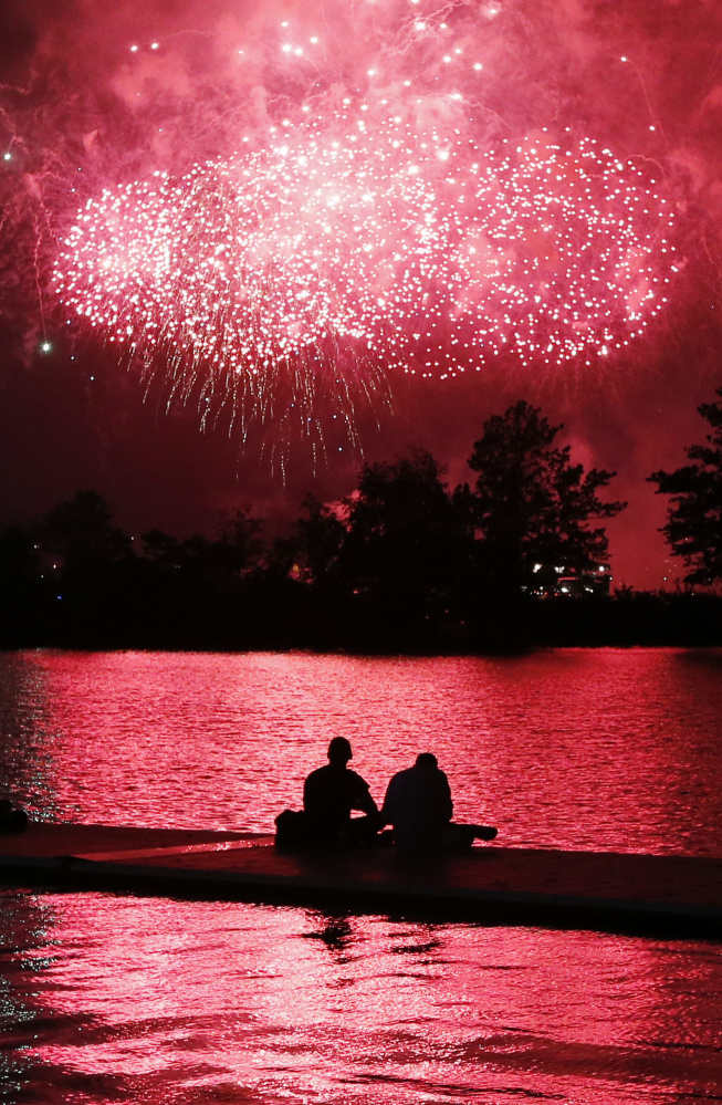 Fireworks explode over the Charles River in Boston on Thursday as boaters take in the scene.