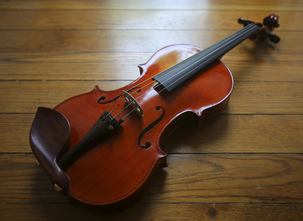 Clancy went from not being able to “sharpen a pencil,” her father says lovingly, to crafting violins, including this one.