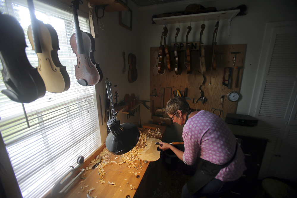 Rose Clancy carves a flat section into a violin piece in her studio in Chatham, Mass. “There’s a real joy to making an instrument,” she said, “then using it to play music.” She founded the Chatham Fiddle Company three years ago and hosts concerts by top performers.