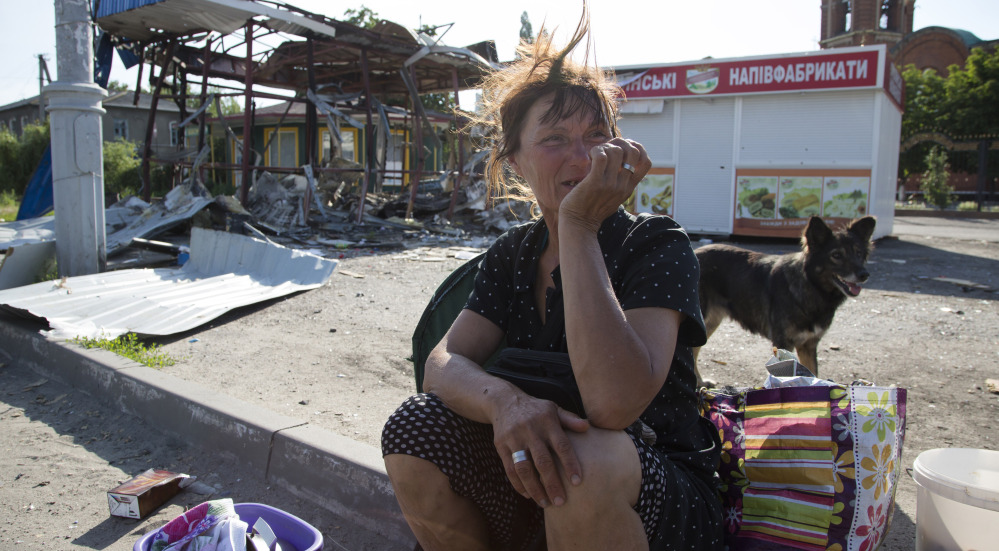 A woman sits near a destroyed shop in the city of Slovyansk, in the Donetsk region of eastern Ukraine, on Saturday. By late afternoon, Ukrainian troops were fully in control of rebel headquarters in Slovyansk, a city of about 100,000.