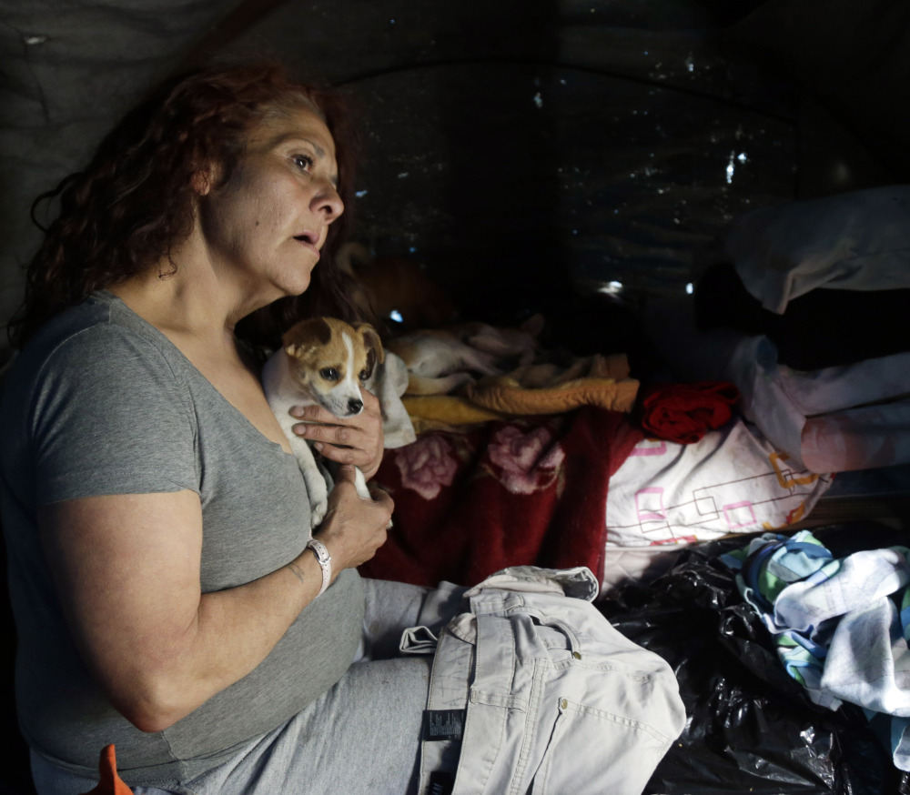 Maria Esther Salazar holds a dog in her tent in the Jungle, a homeless encampment in San Jose, Calif., last March. The Destination: Home pilot program works to place people like Salazar in their own apartments.