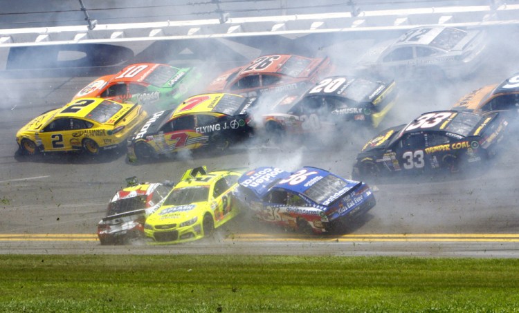 Kasey Kahne, front left, Paul Menard, 27, and Reed Sorenson, 36, are among the cars that crashed coming out of the backstretch going in to turn 3 during the NASCAR Sprint cup Series auto race at Daytona International Speedway in Daytona Beach, Fla., on Sunday