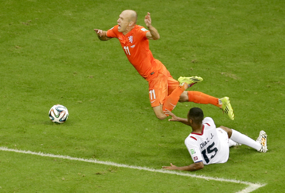 Netherlands’ Arjen Robben, top, is fouled by Costa Rica’s Junior Diaz during the World Cup quarterfinal soccer match between the Netherlands and Costa Rica at the Arena Fonte Nova in Salvador, Brazil, Saturday.
