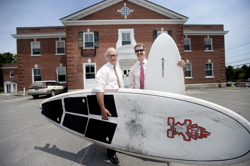 Prosecutor John Connelly and defense attorney Rick Winling hold their surfboards outside York County Superior Court in Alfred.