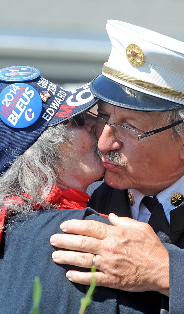 Rangeley Assistant Fire Chief Steve Grant gets a kiss from Lucille Gilbert of St. Georges Sunday in Lac-Megantic, Quebec.