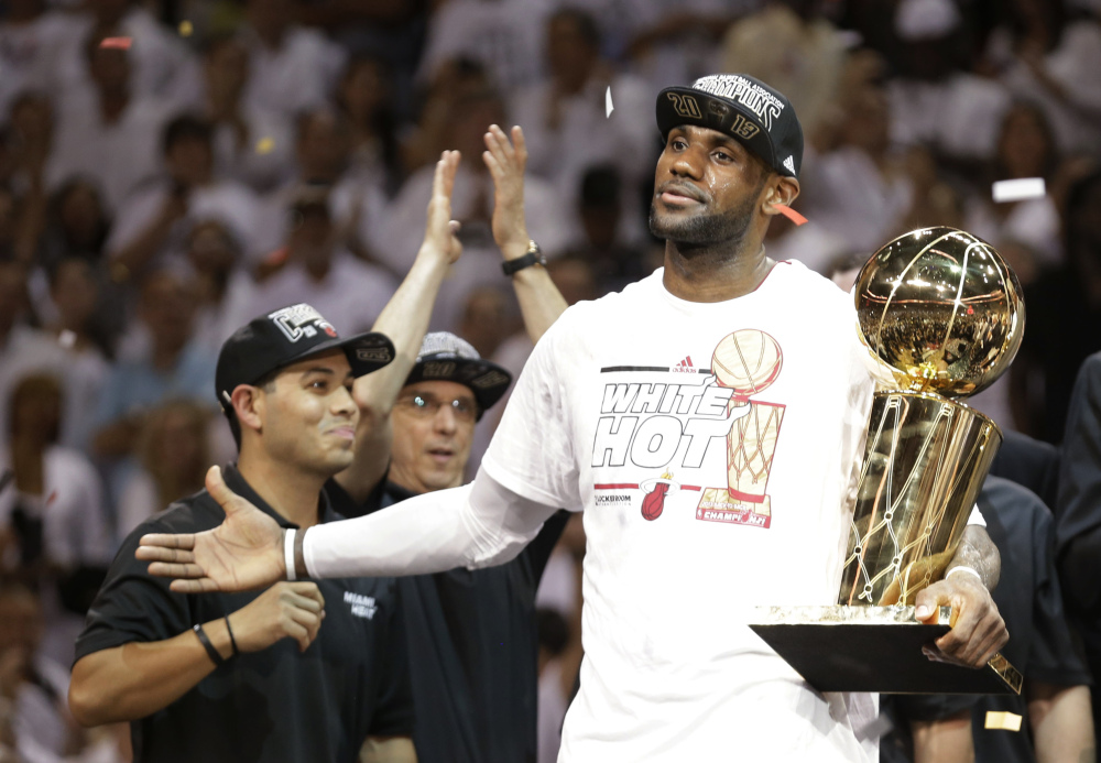 Miami Heat’s LeBron James holds the the Larry O’Brien NBA championship trophy last year.