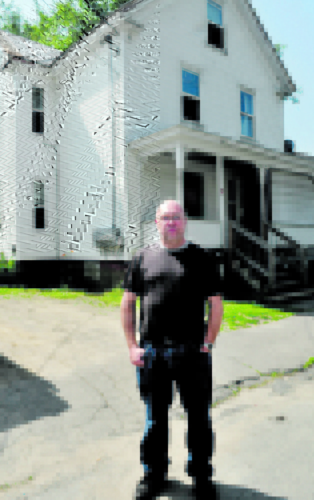Former Oakland police Officer Jim Hamilton stands outside the Summer Street apartment building in Waterville where he discovered the body of his grandmother Evelyn Pomerleau,in 1989.