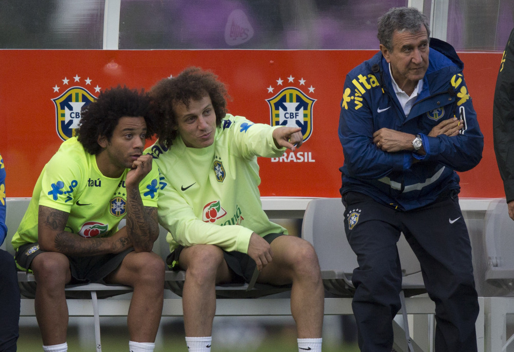 David Luiz, center, talks with Marcelo as Brazil’s team coordinator, Carlos Alberto Parreira, stands next to them during practice. Brazil needs players to come through with the loss of Neymar, its star forward.